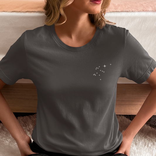 Woman wearing Aquarius constellation t-shirt on a wooden floor.
