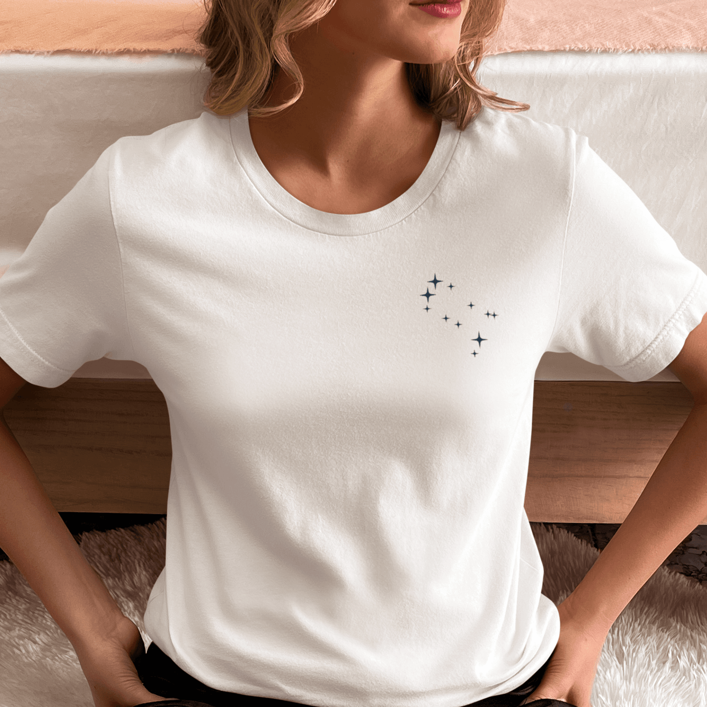 Woman wearing a white t-shirt with Gemini constellation stars.