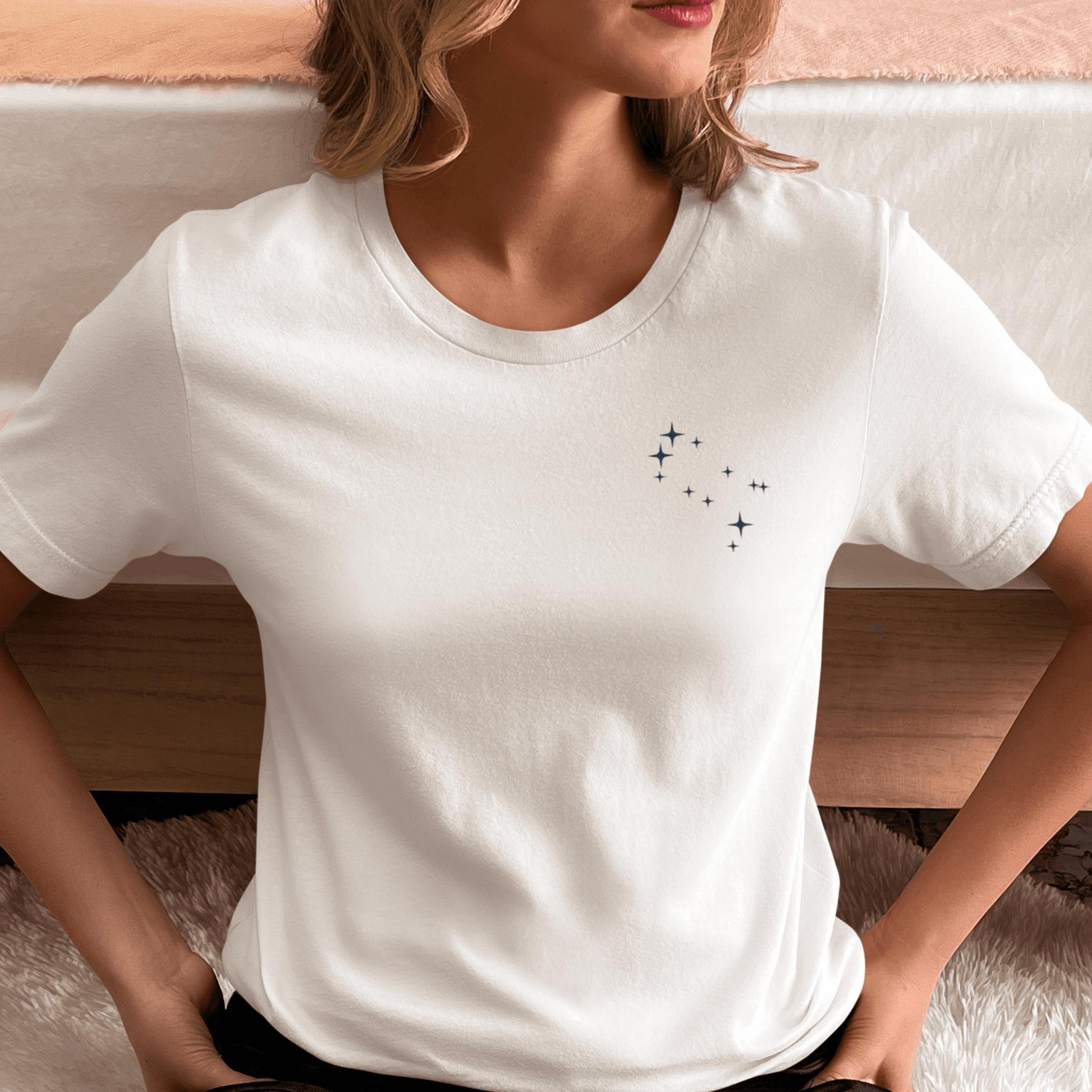 Woman wearing a white t-shirt with Gemini constellation stars.