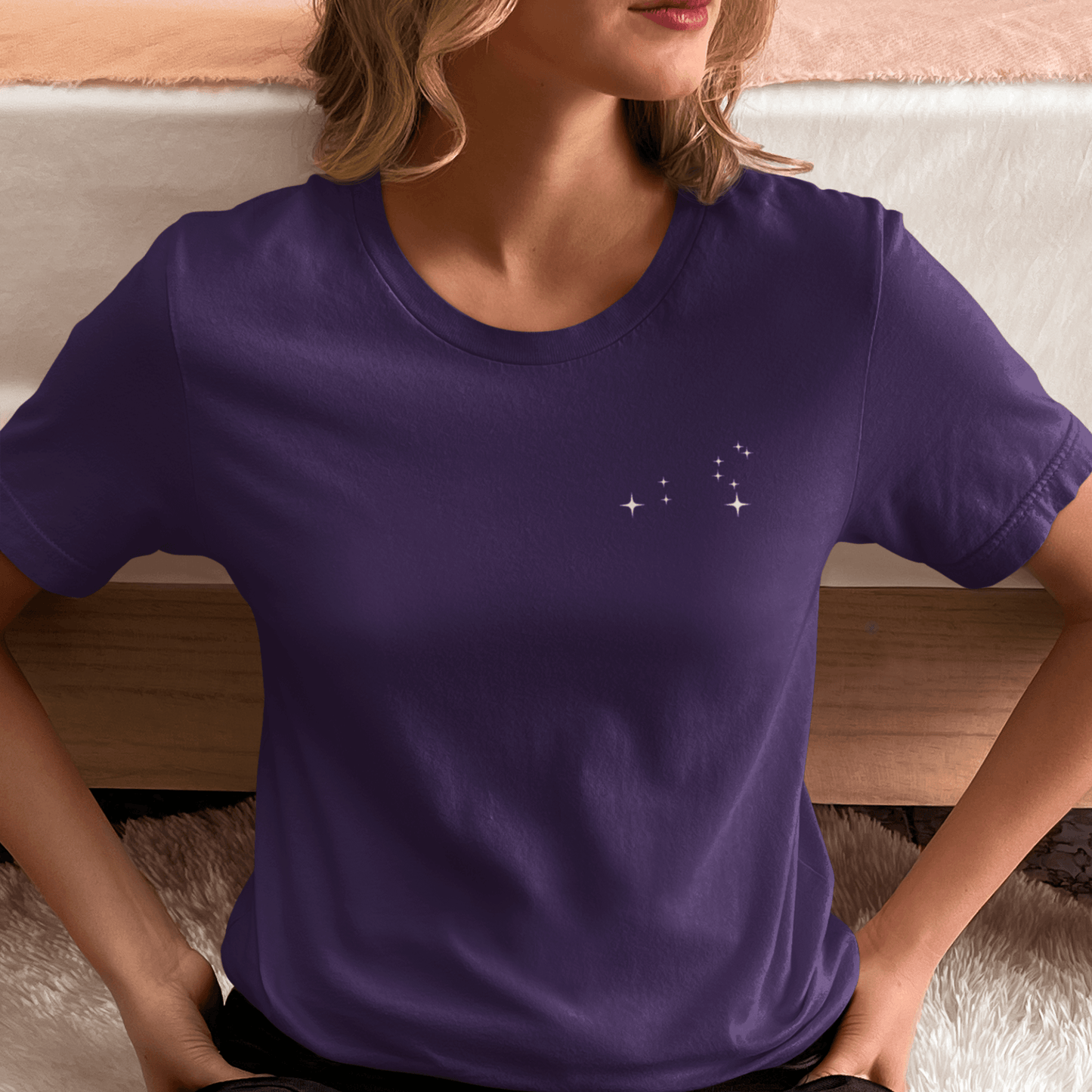 Woman wearing a purple t-shirt with Leo constellation stars.