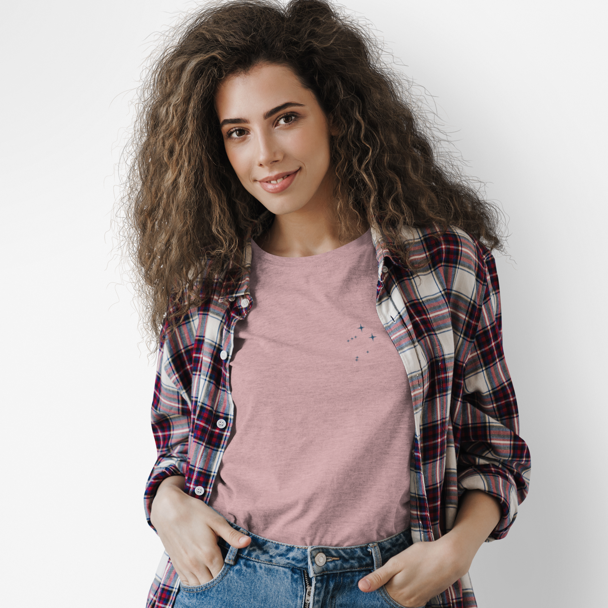 Woman wearing an orchid Libra constellation tshirt and a flannel with a white background.