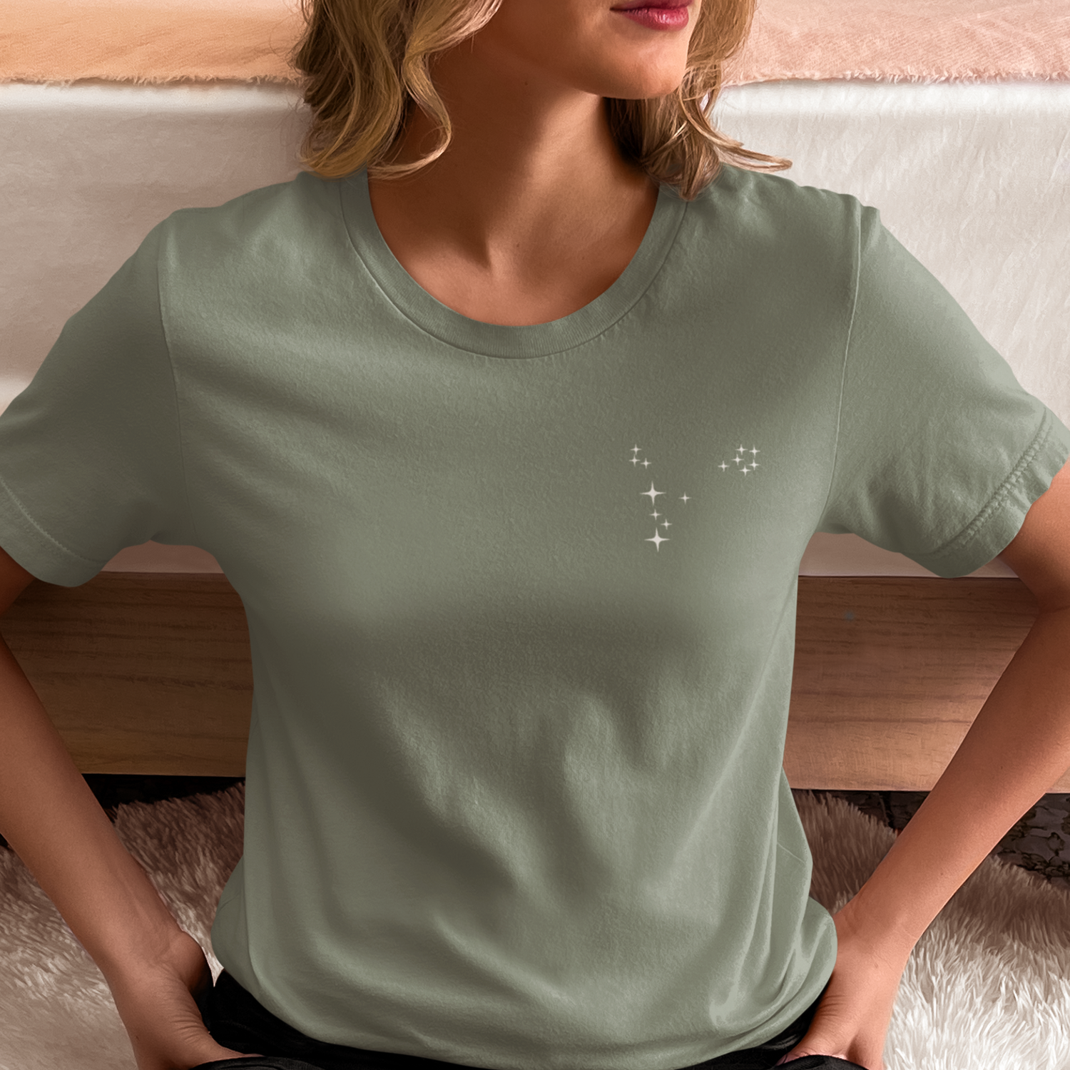 Woman wearing a sage t-shirt with Pisces constellation stars.