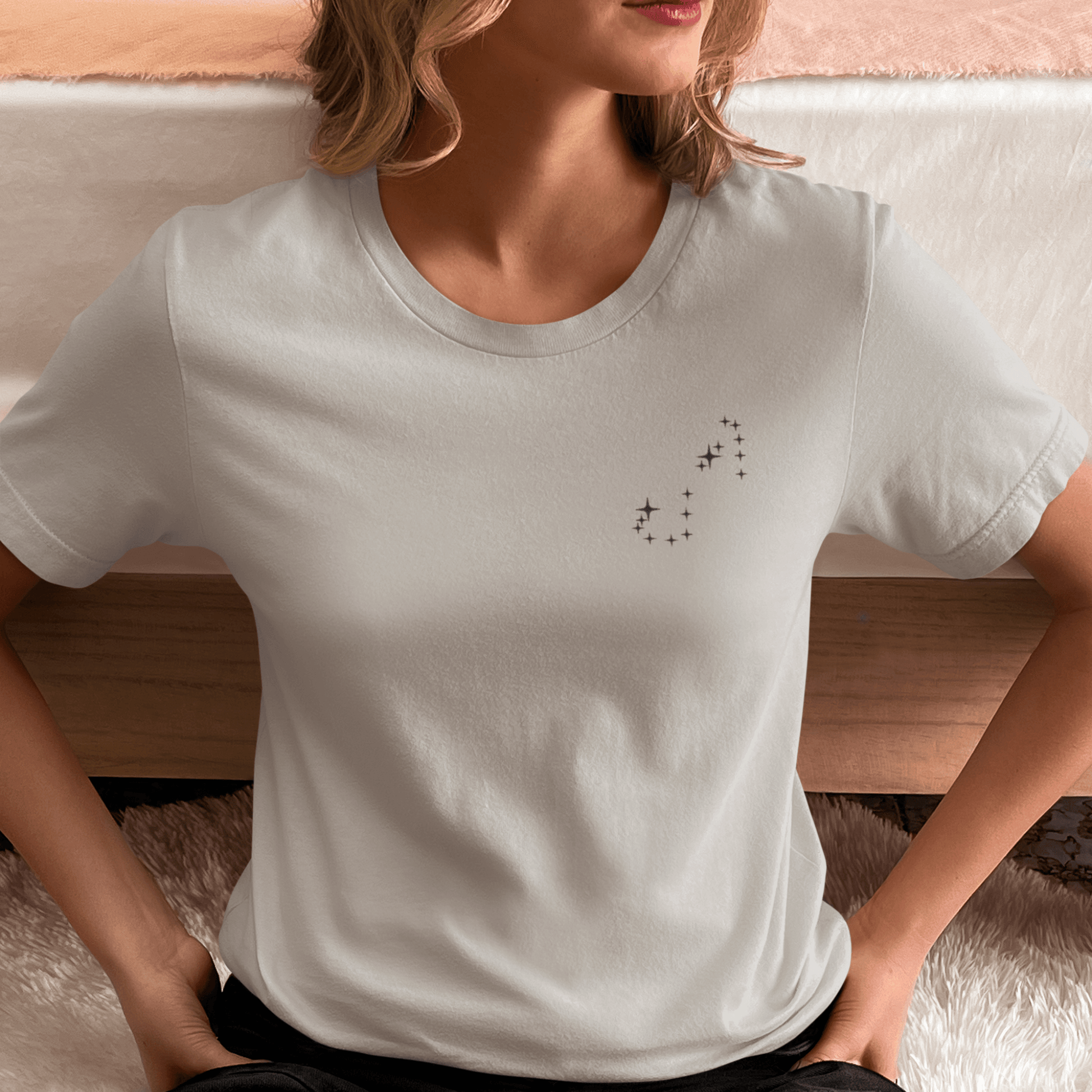 Woman wearing a silver t-shirt with Scorpio constellation stars.