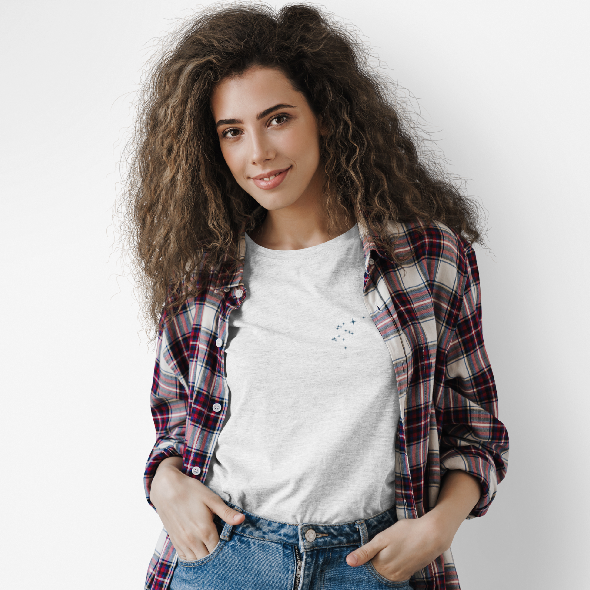 Woman wearing a plaid shirt over a Aquarius constellation t-shirt on a plain background